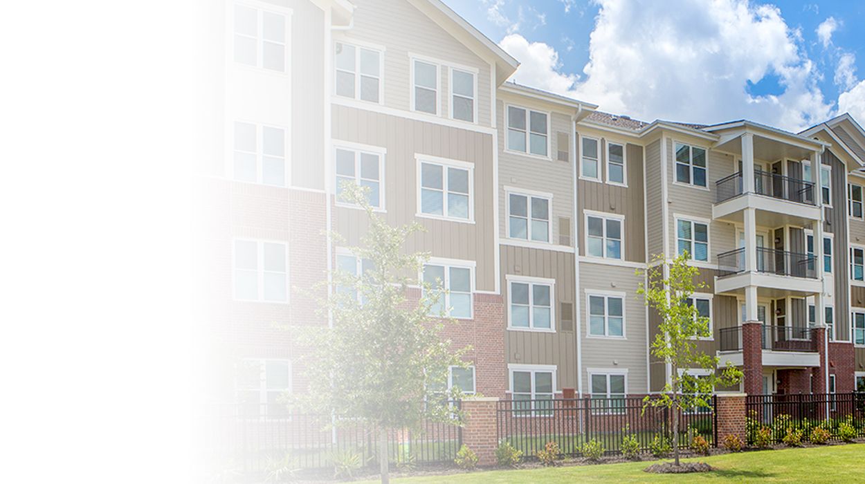 white fade outside of apartments The Delaney at Parkway Lakes senior living community