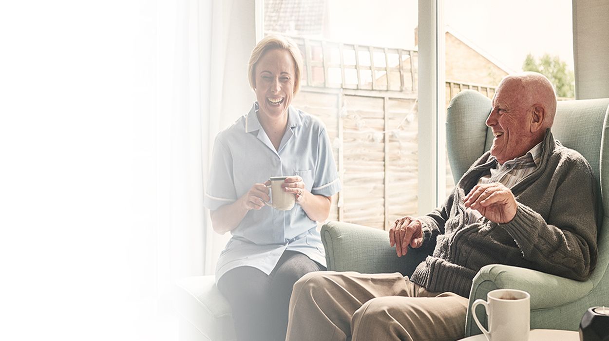 assisted living father and daughter enjoying cups of tea and coffee The Delaney at Parkway Lakes