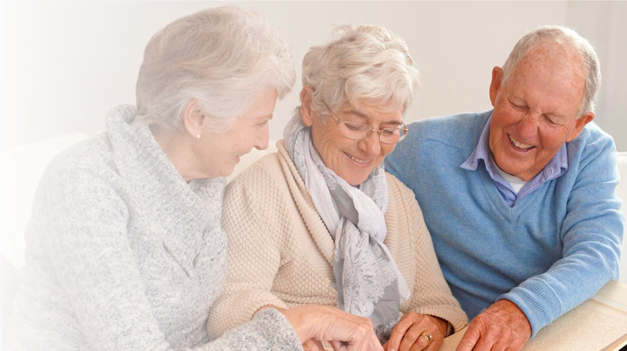 elderly women and man looking through picture books and events at The Delaney at Parkway Lakes