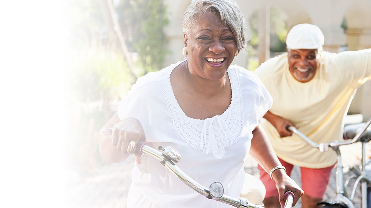 white fade and African American couple riding bikes enjoying independent living at The Delaney at Parkway Lakes