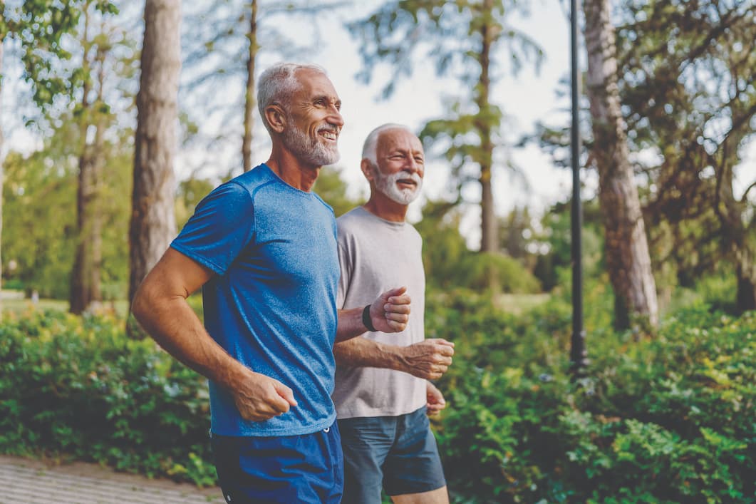 Senior men running through forest