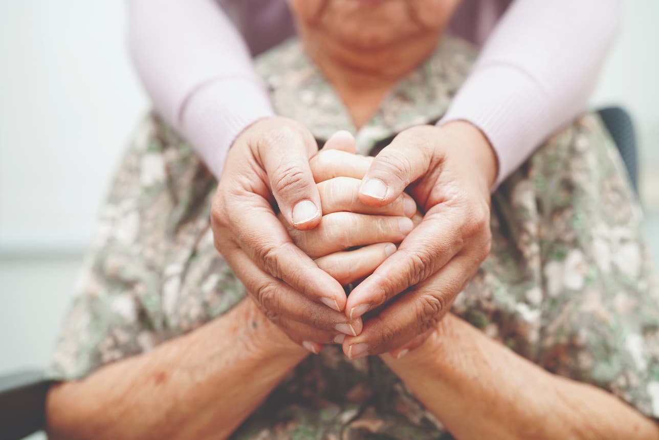 close up of senior women holding hands