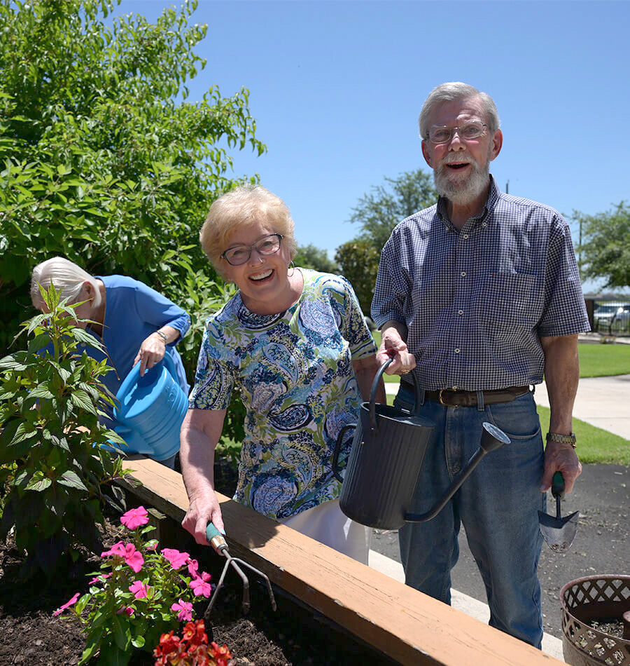 Senior couple gardening at raised planter beds
